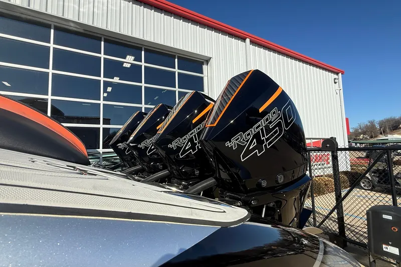 Slide: The Image of Four Racing 450 outboard motors on a 2017 MTI 42V boat, near a modern building. - 6