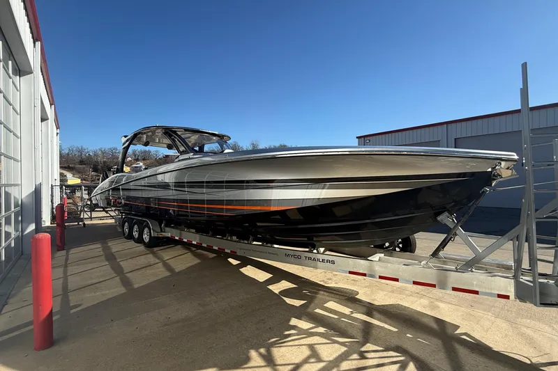 Slide: The Image of 2017 MTI 42V boat on trailer, parked outdoors under clear blue sky. - 9