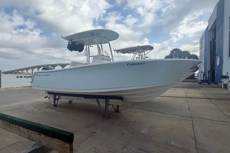 The Image of 2022 Sportsman Open 232 Center Console boat on dock, cloudy sky background. - 0