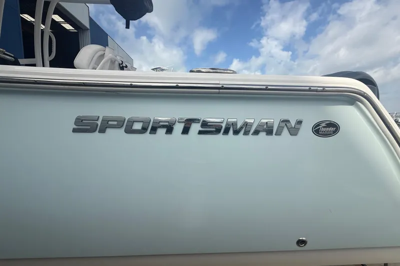 Slide: The Image of 2022 Sportsman Open 232 Center Console boat with logo, under a partly cloudy sky. - 11