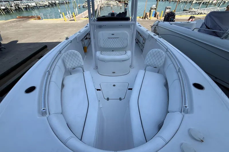 Slide: The Image of 2022 Sportsman Open 232 Center Console boat interior with white seating and waterfront view. - 23
