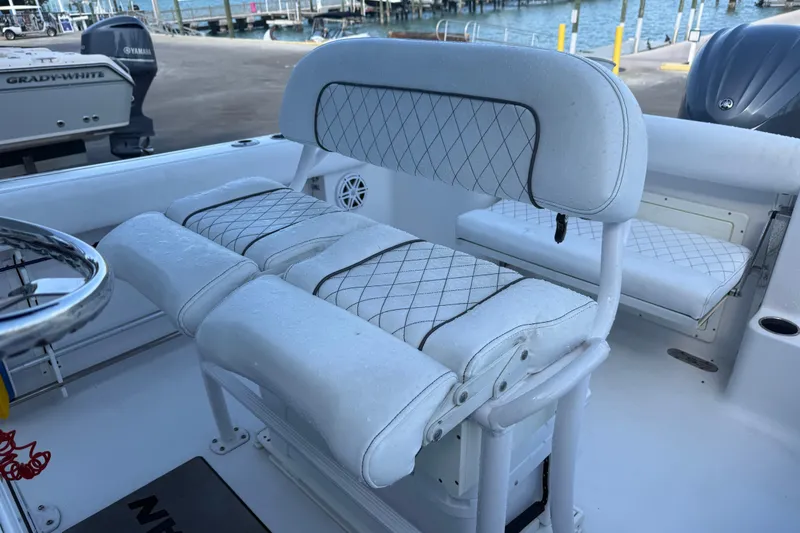 Slide: The Image of 2022 Sportsman Open 232 Center Console boat with cushioned seating and steering wheel. - 46