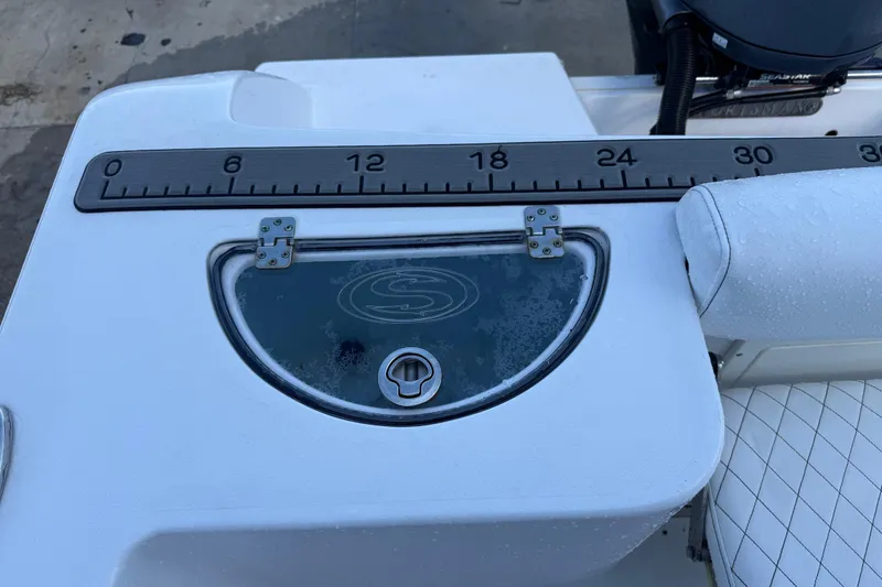 Slide: The Image of 2022 Sportsman Open 232 Center Console boat with measuring ruler and storage compartment. - 50