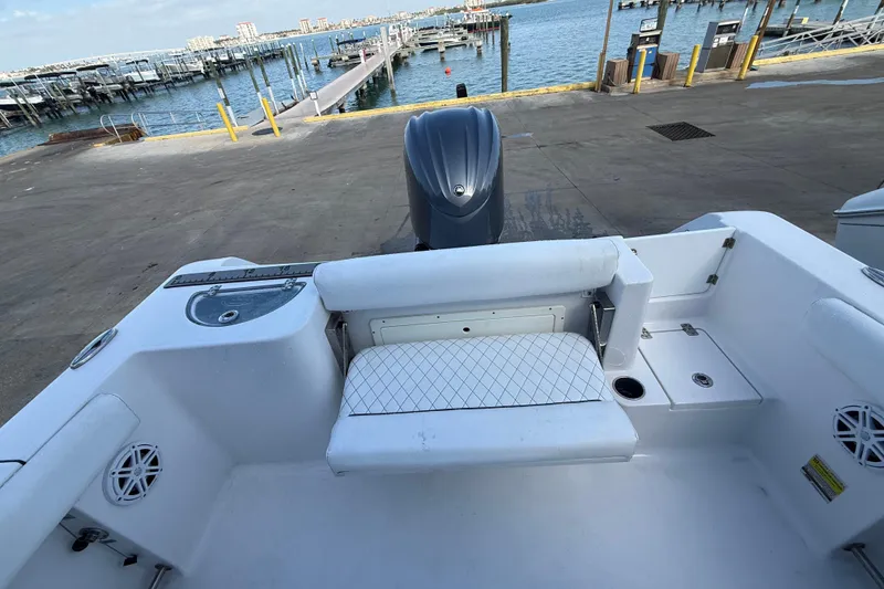 Slide: The Image of 2022 Sportsman Open 232 Center Console boat at dock, featuring seating and engine view. - 55