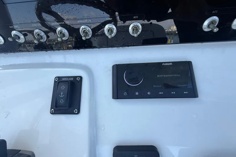 Slide: The Image of Control panel of 2022 Sportsman Open 232 Center Console boat with switches and audio system. - 63