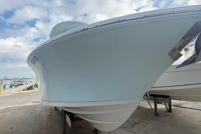 Slide: The Image of 2022 Sportsman Open 232 Center Console boat docked under a cloudy sky. - 7