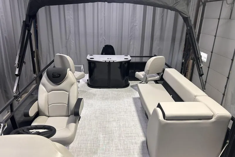 Slide: The Image of 2026 Dockside 22DF boat interior with modern seating and steering wheel, under a canopy. - 2