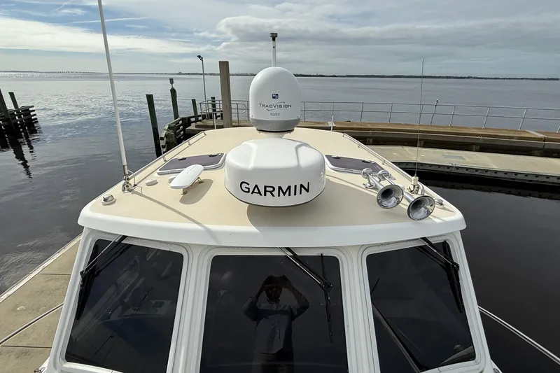 Slide: The Image of 2012 MJM 40z boat with Garmin and TracVision equipment docked by the water. - 15