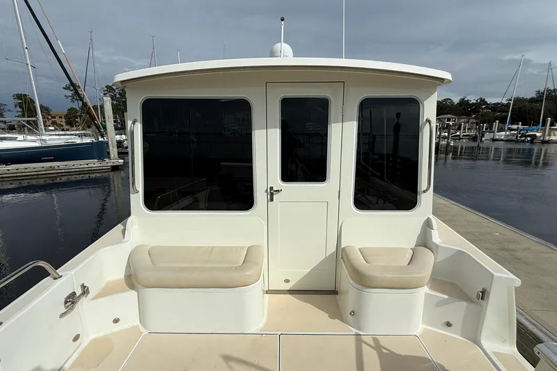 Slide: The Image of 2012 MJM 40z boat docked, featuring cushioned seating and large windows. - 16