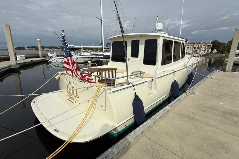 Slide: The Image of 2012 MJM 40z yacht docked, displaying an American flag, with a calm marina backdrop. - 3