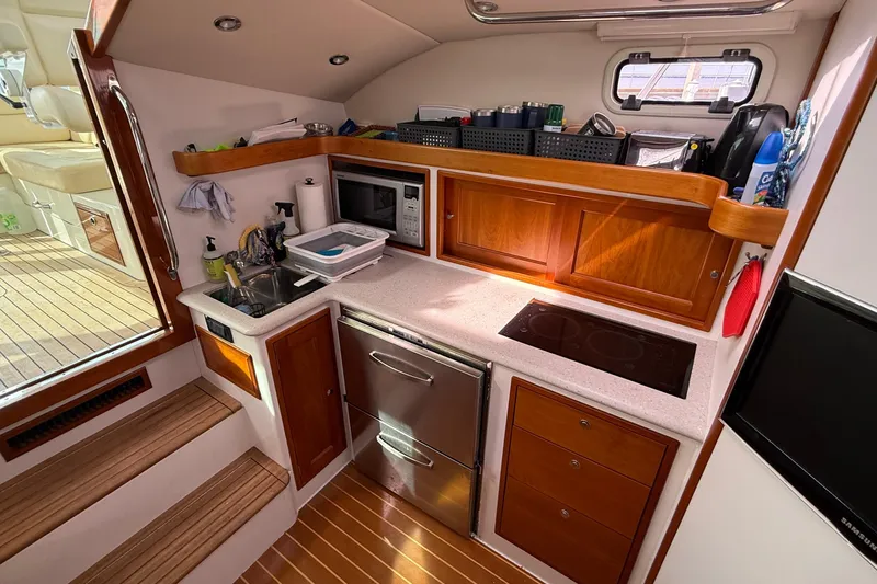Slide: The Image of Compact galley kitchen in 2012 MJM 40z yacht with wooden cabinetry and modern appliances. - 33