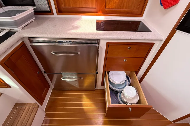 Slide: The Image of Modern kitchen in 2012 MJM 40z yacht with stove, dishwasher, and open drawer with dishes. - 42