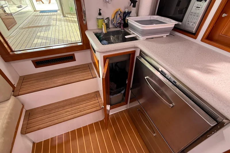 Slide: The Image of Compact galley in 2012 MJM 40z yacht with sink, microwave, and wooden steps. - 43