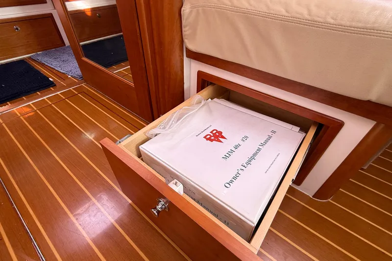 Slide: The Image of Open drawer with MJM 40z owner's manual on wooden boat floor, 2012 model. - 45