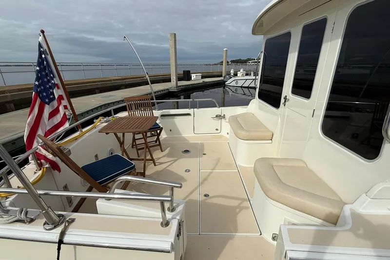 Slide: The Image of 2012 MJM 40z yacht deck with seating, table, and American flag at dock. - 5