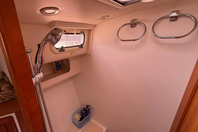 Slide: The Image of Shower area in 2012 MJM 40z yacht with chrome fixtures and storage shelf. - 54