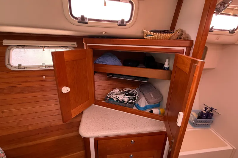 Slide: The Image of 2012 MJM 40z yacht interior with open wooden cabinet and storage items. - 55