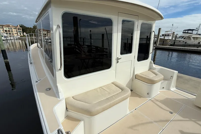Slide: The Image of 2012 MJM 40z yacht at marina, featuring cushioned seating and sleek design. - 7