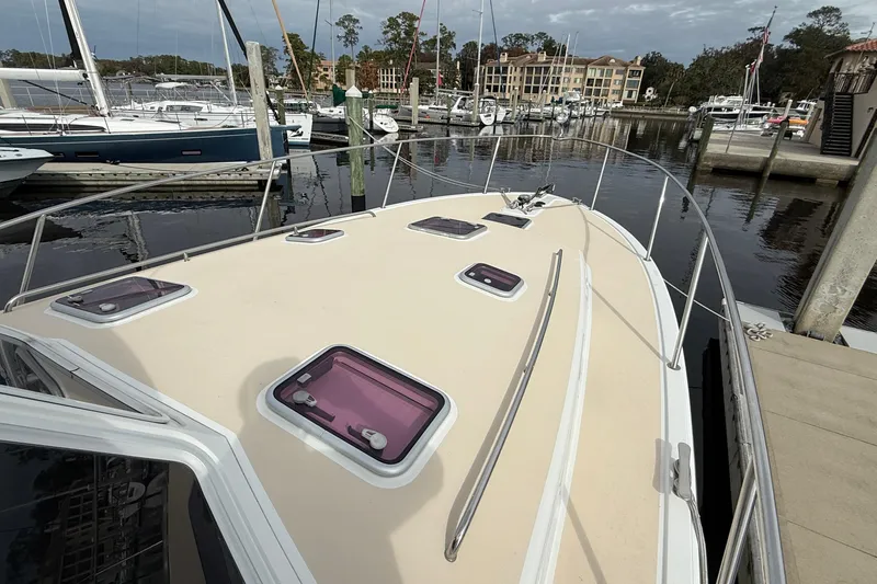Slide: The Image of 2012 MJM 40z yacht docked at marina, showcasing sleek deck design and multiple hatches. - 9