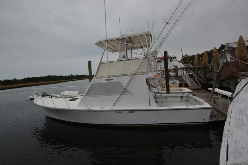 The Image of 1983 Key West #1 Sport Fish boat docked at marina under cloudy sky. - 1