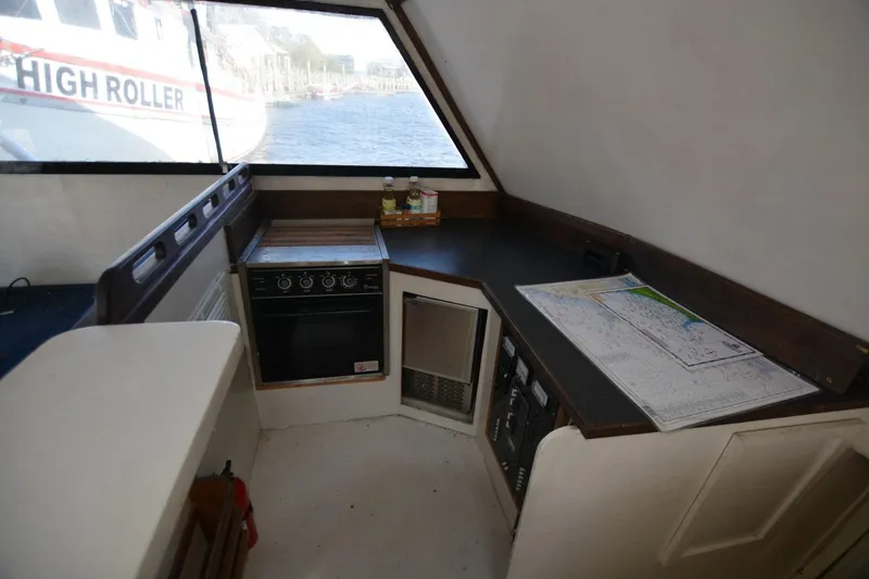 Slide: The Image of 1983 Key West #1 Sport Fish boat interior with navigation maps and kitchen area. - 12