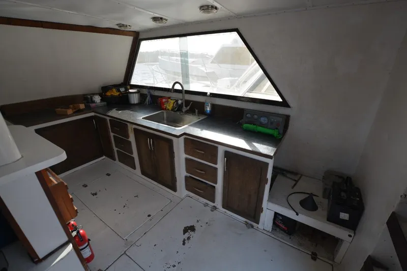 Slide: The Image of 1983 Key West #1 Sport Fish boat interior with kitchen sink and wooden cabinets. - 13