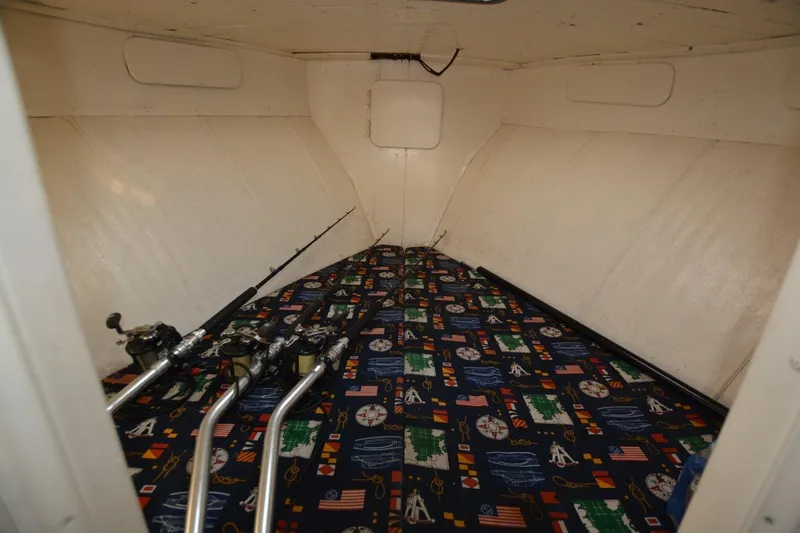 Slide: The Image of Interior of 1983 Key West #1 Sport Fish boat with fishing rods and patterned bedding. - 14