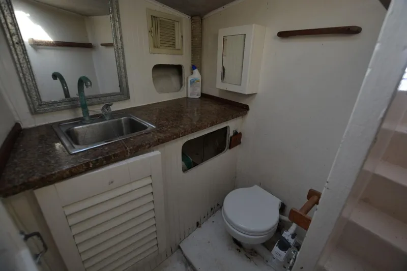 Slide: The Image of 1983 Key West #1 Sport Fish boat bathroom with sink, mirror, and toilet. - 15