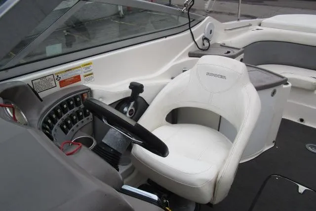 Slide: The Image of 2009 Rinker 276 Captiva Bowrider cockpit with steering wheel and white captain's chair. - 11