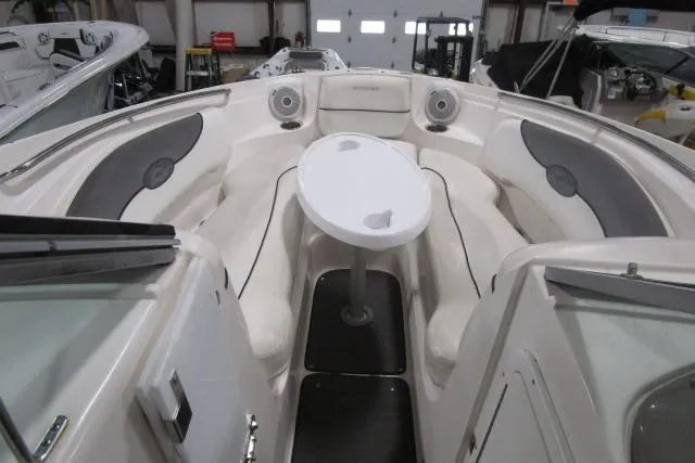 Slide: The Image of 2009 Rinker 276 Captiva Bowrider interior with seating and table in a showroom. - 12