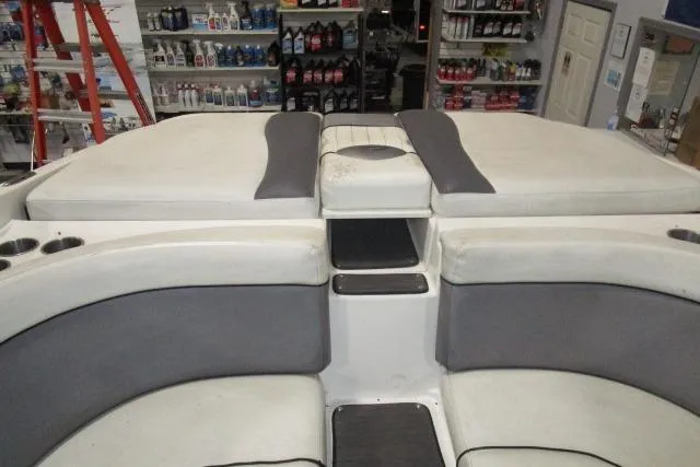 Slide: The Image of 2009 Rinker 276 Captiva Bowrider interior with gray and white seating in a store setting. - 16