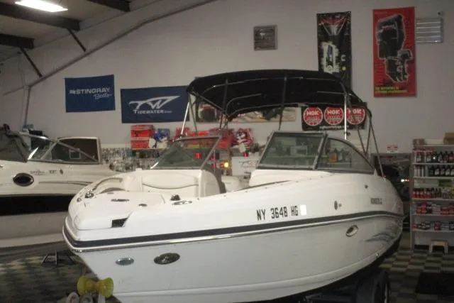 Slide: The Image of 2009 Rinker 276 Captiva Bowrider in showroom, featuring sleek design and canopy. - 18