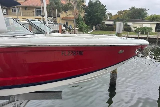 Slide: The Image of 2016 Cobalt A28 boat with red hull docked near waterfront homes. - 17