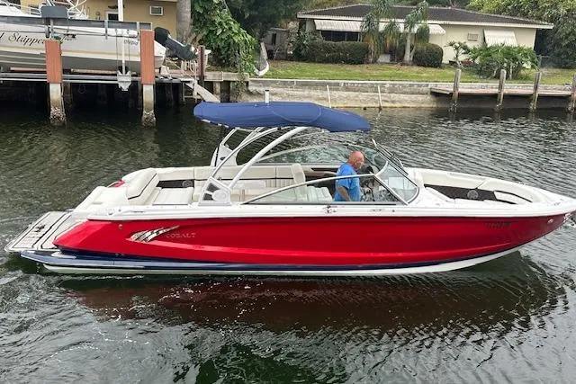 Slide: The Image of 2016 Cobalt A28 boat with red hull and blue canopy on a calm waterway. - 26