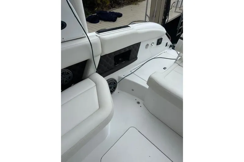 Slide: The Image of 2016 Cobalt A28 boat interior with white seating and speaker system. - 30