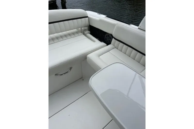 Slide: The Image of 2016 Cobalt A28 boat interior with white leather seating and table by the water. - 31