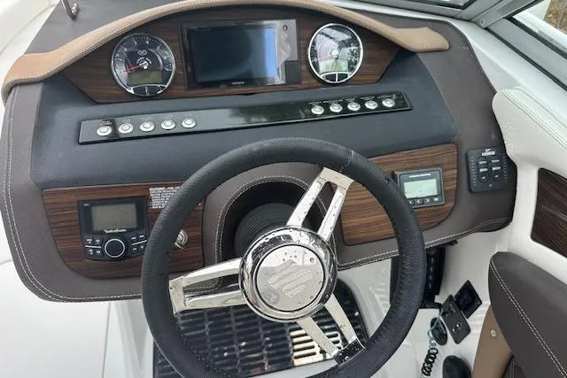 Slide: The Image of Steering console of 2016 Cobalt A28 boat with wood accents and modern controls. - 40