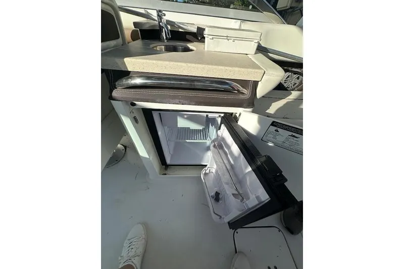 Slide: The Image of 2016 Cobalt A28 boat interior with open mini fridge and sink. - 49
