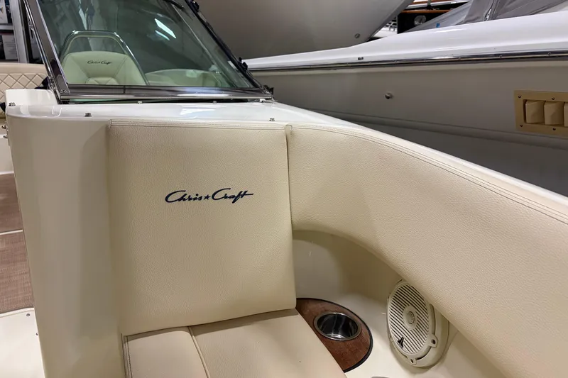 Slide: The Image of 2020 Chris-Craft Launch 28 GT boat interior with logo, beige seating, and speaker. - 18