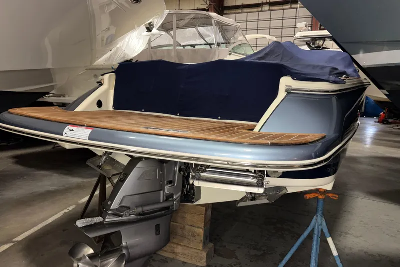 Slide: The Image of 2020 Chris-Craft Launch 28 GT boat in storage, featuring a sleek design and wooden deck. - 2