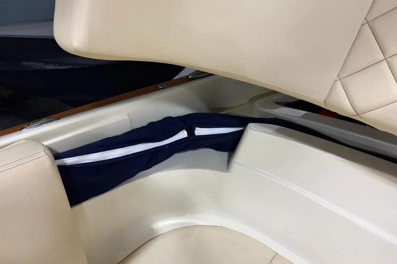 Slide: The Image of 2020 Chris-Craft Launch 28 GT interior storage compartment with beige seating and blue cover. - 27