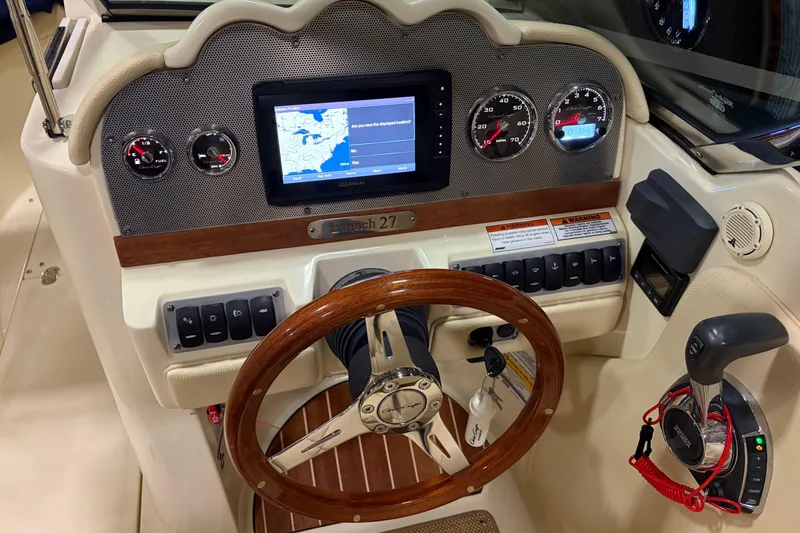 Slide: The Image of 2020 Chris-Craft Launch 28 GT dashboard with GPS, gauges, and wooden steering wheel. - 6