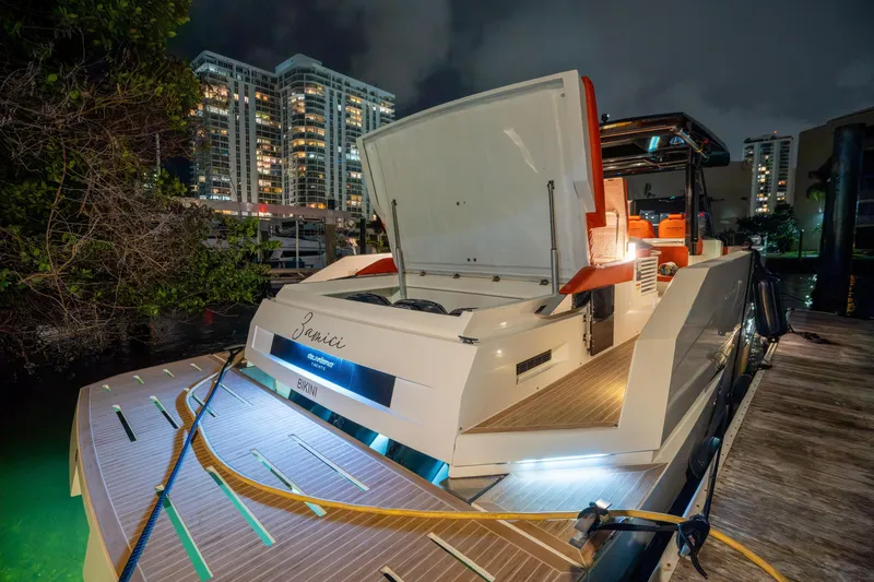 Slide: The Image of 2023 De Antonio Yachts D42 Open docked at night, city skyline in background. - 10