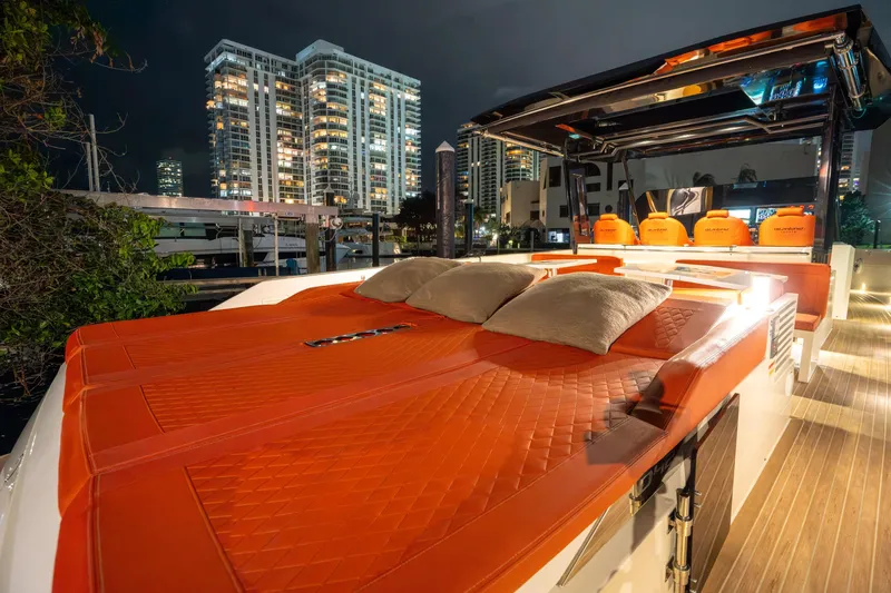 Slide: The Image of 2023 De Antonio Yachts D42 Open with luxurious orange seating, city skyline backdrop. - 11