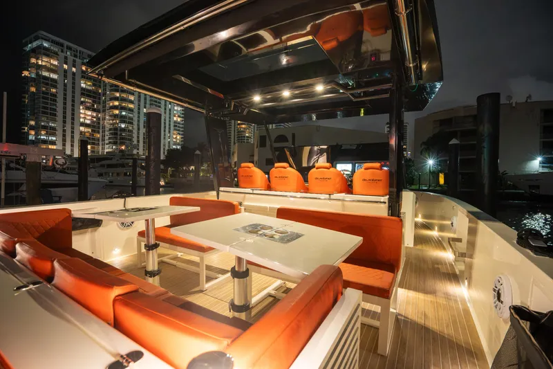 Slide: The Image of 2023 De Antonio Yachts D42 Open, luxurious deck with orange seating, city skyline at night. - 14