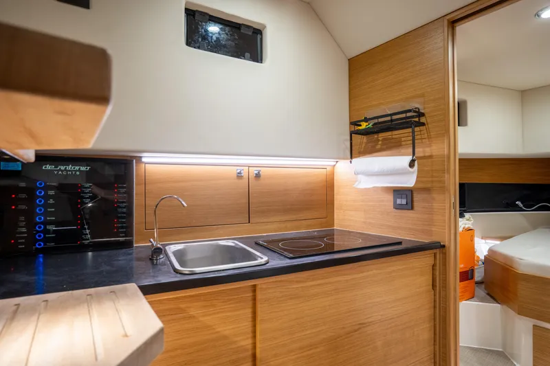 Slide: The Image of Modern kitchen interior of 2023 De Antonio Yachts D42 Open, featuring sleek wood finishes and compact design. - 23