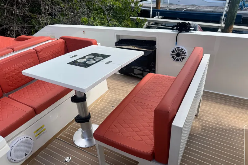 Slide: The Image of 2022 De Antonio Yachts D42 Open with red seating and a white table on deck. - 5