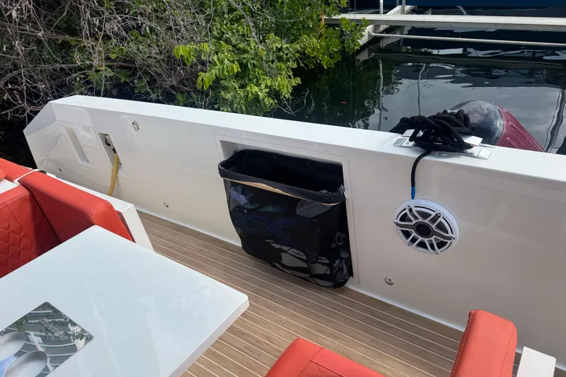 Slide: The Image of 2022 De Antonio Yachts D42 Open deck with red seating and speaker. - 6