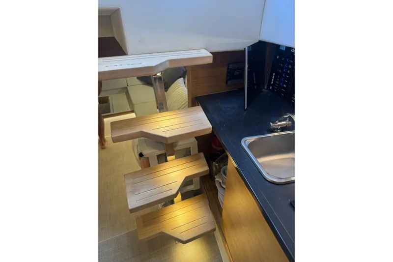 Slide: The Image of Interior view of 2022 De Antonio Yachts D42 Open, featuring wooden stairs and kitchenette. - 7