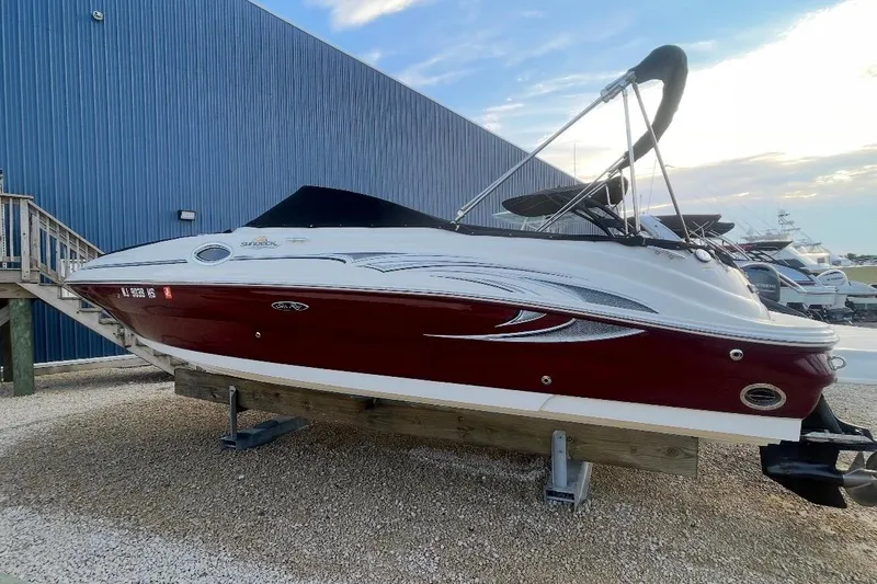 The Image of 2006 Sea Ray 240 Sundeck boat on display, red and white exterior, docked outdoors. - 0